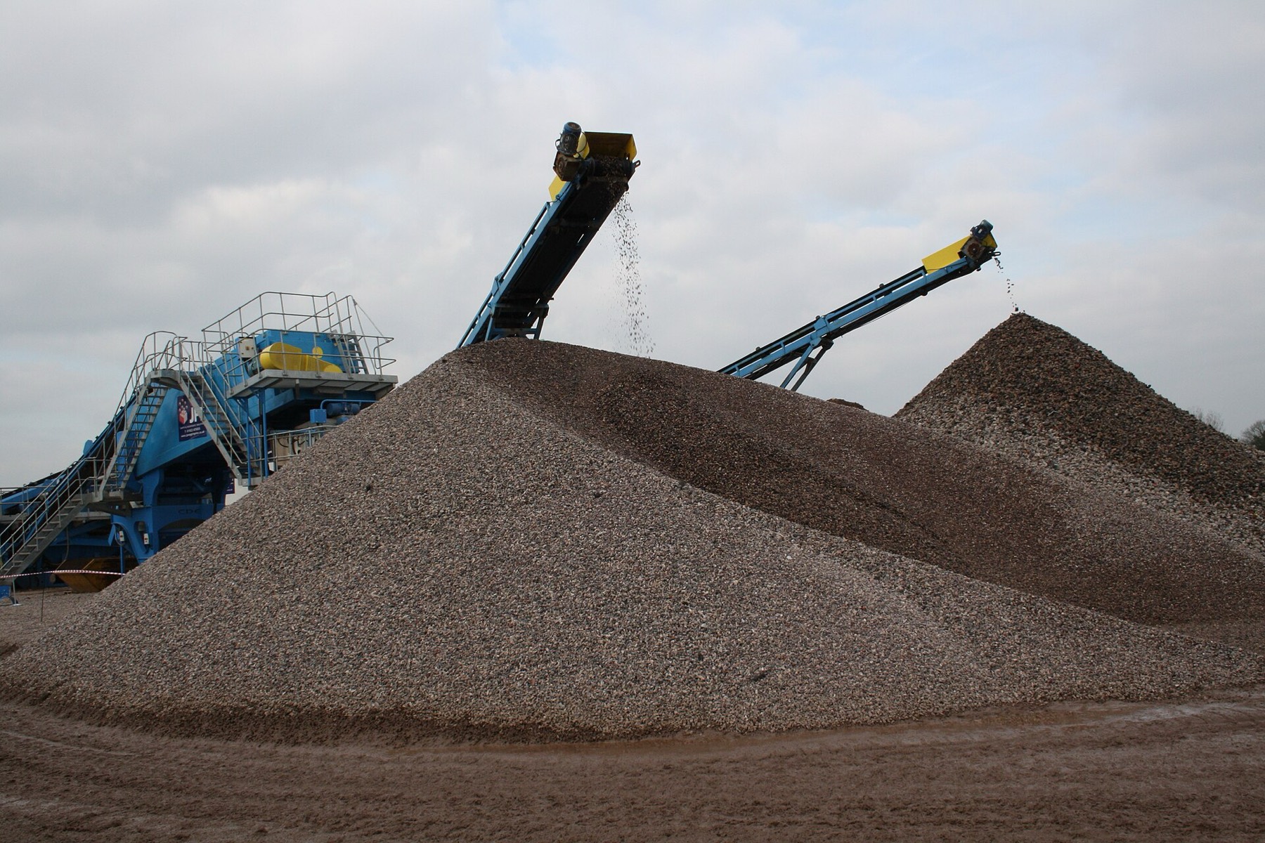 Brown heaps of recycled aggregate beside crushing plant